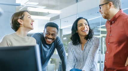 Diverse Group of Four Talented Young Professionals Having Team Building Conversation, Joking and Having Fun. Talented Young People in Modern Office.