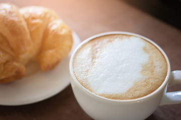 Latte art ,Croissant and moka pot with Roasted coffee on black background in the morning and instagram style filter photo vintage tone