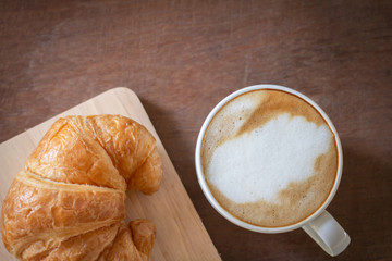 Latte art ,Croissant and moka pot with Roasted coffee on black background in the morning and instagram style filter photo vintage tone