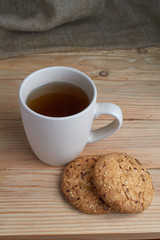 Oatmeal cookies with sunflower seeds near cup of tea.