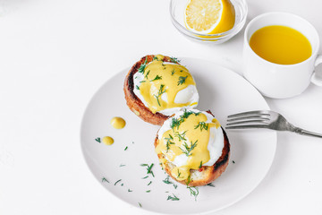 Traditional breakfast. Eggs benedict  on a plate with orange juice