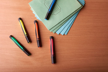 colored markers and notebooks on the school table