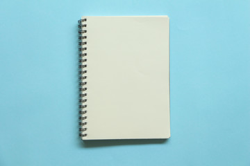 Blank note book on blue background.