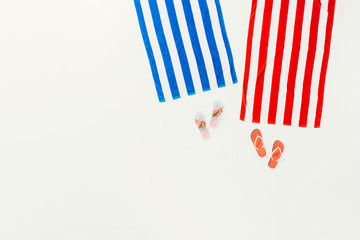 Obraz premium top view of striped towels and flip flops isolated on white