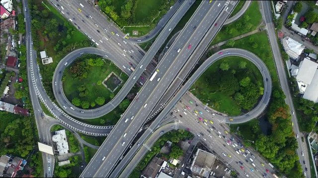 4K. Aerial view of infinity highway road interchange with busy urban traffic speeding on the road. Junction network of transportation in Bangkok, Thailand. taken by drone
