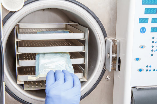 Nurse is sterilizing bandages in autoclave at dental office