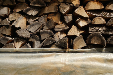 Wooden logs stacked up to become firewood.