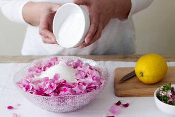A woman prepares jam from roses, ingredients for jam from roses. Rustic style.