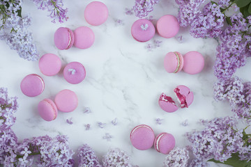 Macaroons on a marble background with lilac flowers, Light background, Confectionery in a blogger style