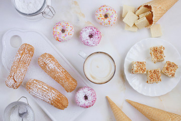 Eclairs and donuts with coffee on a marble background, Light background, Confectionery in a blogger style