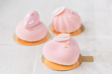 Pink mousse-cake. French dessert and flowers eucalyptus on a white background. pastel colors