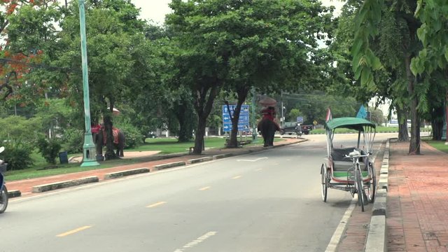  Phra Nakhon Si Ayutthaya Province / Thailand - May 28 2018 : tourist on elephant ride at Ayutthaya Historical Park slow motion shot