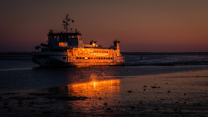 The sky turns purple after sundown when the ferry has left the harbour of the Wadden Island of Schiermonnikoog for Lauwersoog on the mainland on a late September evening (Friesland, the Netherlands)