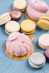 Pink mousse-cake. French macaroon dessert and flowers eucalyptus on a turquoise background. pastel colors