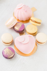 Pink mousse-cake. French macaroon dessert and flowers eucalyptus on a white background. pastel colors