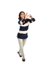 full length portrait of girl wearing striped blue and white jumper and jeans. standing pose on white studio background
