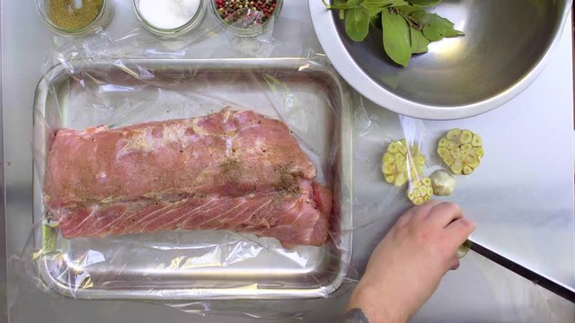 Chef marinated meat with garlic and bay leaf