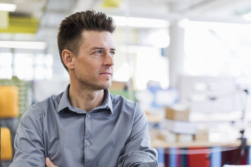 Portrait of confident man in factory looking sideways