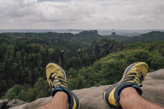 Germany, Saxony, Elbe Sandstone Mountains, Man's Feet On A Hiking Trip Sitting On Rock