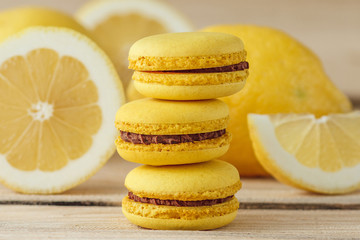 Yellow french macarons with lemons on the wooden boards