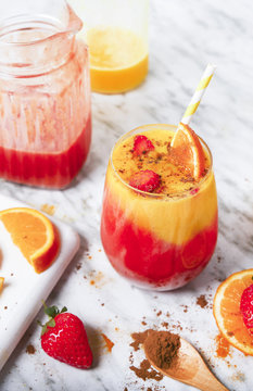 Strawberry And Orange Smoothie With Curcuma And Cinnamon On Marble