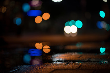 Fototapeta na wymiar Light bokeh dots in the night after rain.