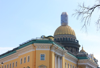 Fototapeta na wymiar Saint Isaac's Cathedral Dome Colonnade View in St. Petersburg, Russia. Orthodox Church and Classic City Architecture Buildings View from Local Street. Saint Petersburg City Landmarks Scenic Image.