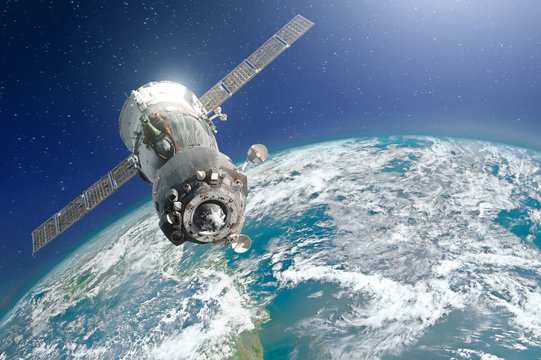 Spaceship piloted by astronauts in the orbit of planet Earth is a blue-green hue. Elements of this image furnished by NASA.