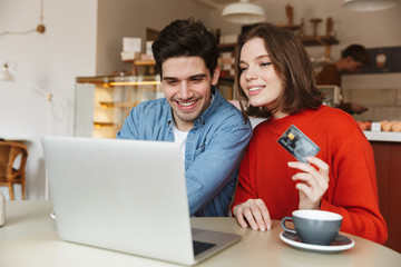 Cheerful young couple showing credit card