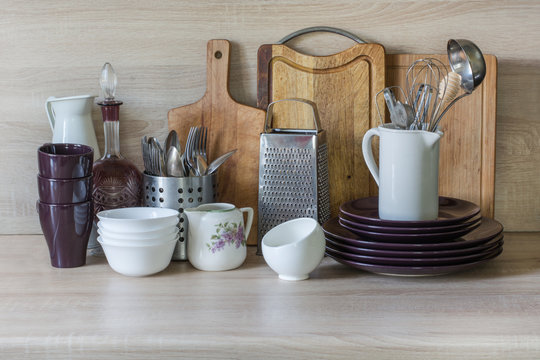 Crockery, tableware, utensils and other different stuff on wooden table-top. Kitchen still life as background for design.