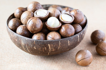 Macadamia nuts whole and cracked in coconut bowl