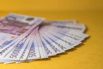 Many euro bills closeup on yellow background