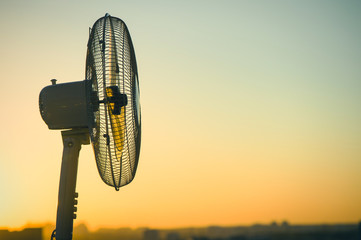 Electric fan ventilator against a background of a clear sunset sky. Concept
