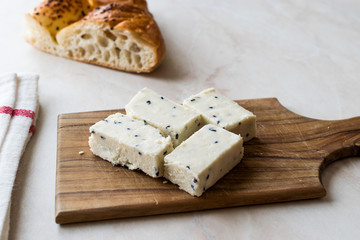 Turkish Feta Cheese with Black Cumin (Sesame) Seeds on Wooden Surface with Knife.