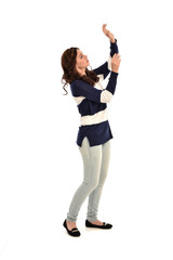 full length portrait of girl wearing striped blue and white jumper and jeans. standing pose on white studio background