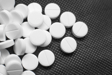 White pills on black background closeup