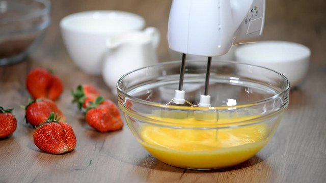 Beaten Eggs with Mixer Whisks in Bowl.