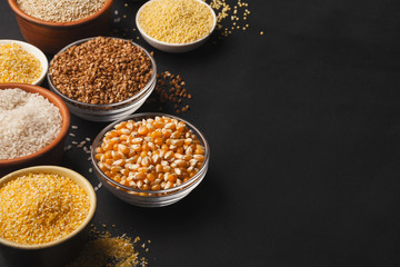 Various gluten free groats on black background with copy space