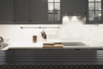 Blurred background. Modern defocused grey kitchen or cafe with wooden tabletop and space for you.