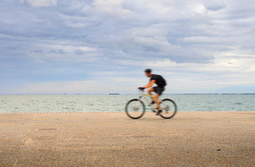 Man riding a bicycle waterfront