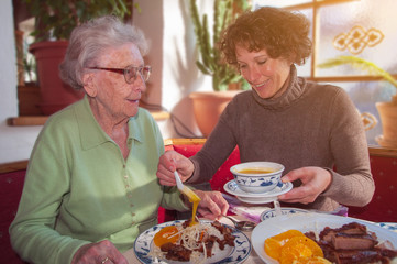 Seniorin mit Enkelin beim Essen im Restaurant