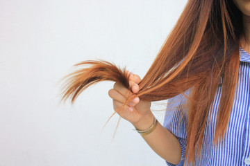 Woman holding at damaged splitting ends of hair, Haircare concept