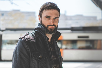 Attractive confident mature man with beard on blurred background. Fashionable cool male dressed in...