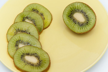 sweet ripe kiwi fruits on white, Kiwi cut into slices lay on a yellow plate, serving fruit