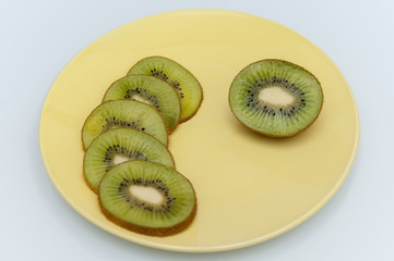 sweet ripe kiwi fruits on white, Kiwi cut into slices lay on a yellow plate, serving fruit