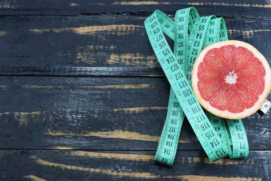 Grapefruit and slimming tape on the table, a symbol of weight loss and diet