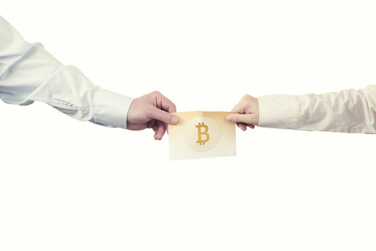 Two hands with paper banknote of cryptocurrency bitcoin. Symbol BTC. Bitcoin bifurcation
