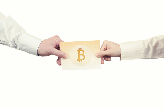Two hands with paper banknote of cryptocurrency bitcoin. Symbol BTC. Bitcoin bifurcation