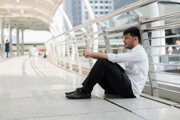 Handsome hipster modern business man using smart phone in the city. concept of communication online.