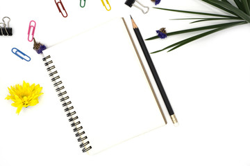 top view book, pencil for note isolated on white background with colorful paper clip, black paper clip decorate by chrysanthemum, yellow and purple flower, green leave. Desk office concept, copy space